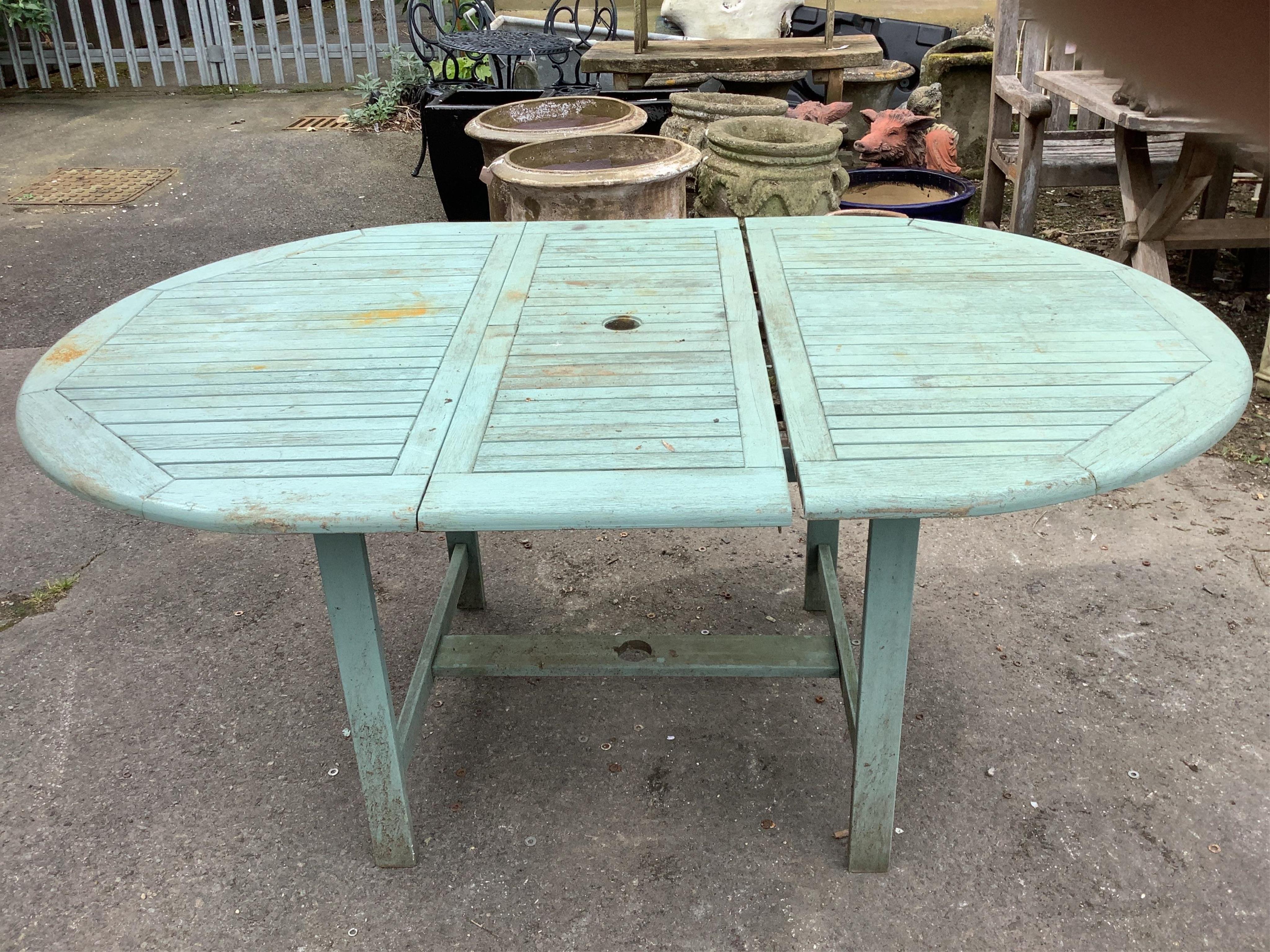 A painted teak extending garden table, width 170cm extended, depth 110cm, height 75cm together with six matching folding armchairs